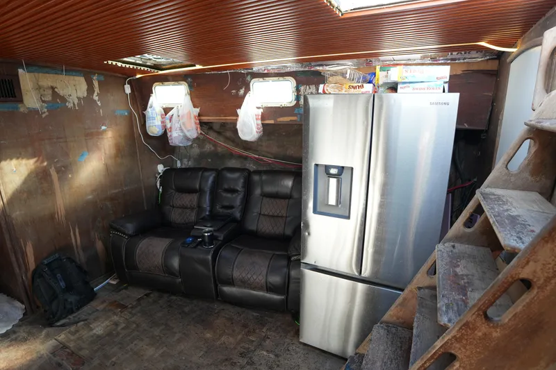 Slide: The Image of Interior of 1990 Endeavour 43 Center Cockpit with leather sofa and stainless steel refrigerator. - 10
