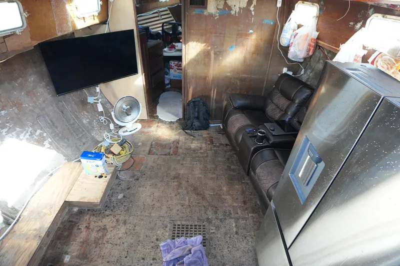 Slide: The Image of Interior of a 1990 Endeavour 43 Center Cockpit with TV, fan, and refrigerator. - 7