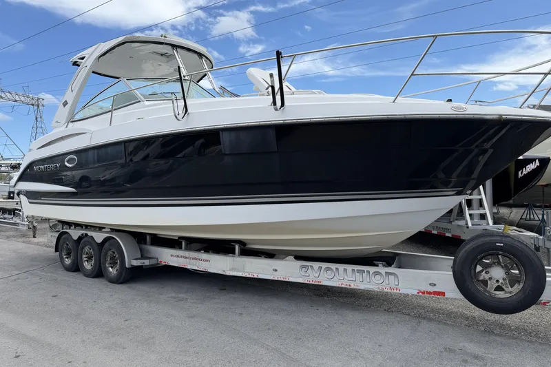 The Image of 2017 Monterey 355 Sport Yacht on trailer, sleek design, black and white exterior. - 0