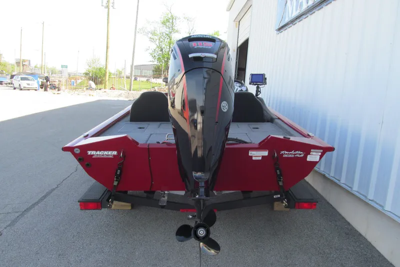 Slide: The Image of 2024 Tracker Pro Team 190 TX boat with outboard motor, parked outdoors. - 4