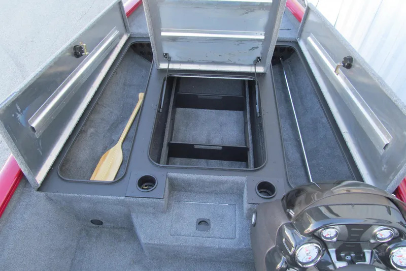 Slide: The Image of 2024 Tracker Pro Team 190 TX boat interior with open storage compartments and paddle. - 8