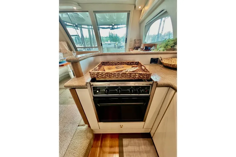 Slide: The Image of 1999 Maxum 4100 SCB yacht kitchen with oven, countertop, and wicker basket. - 11