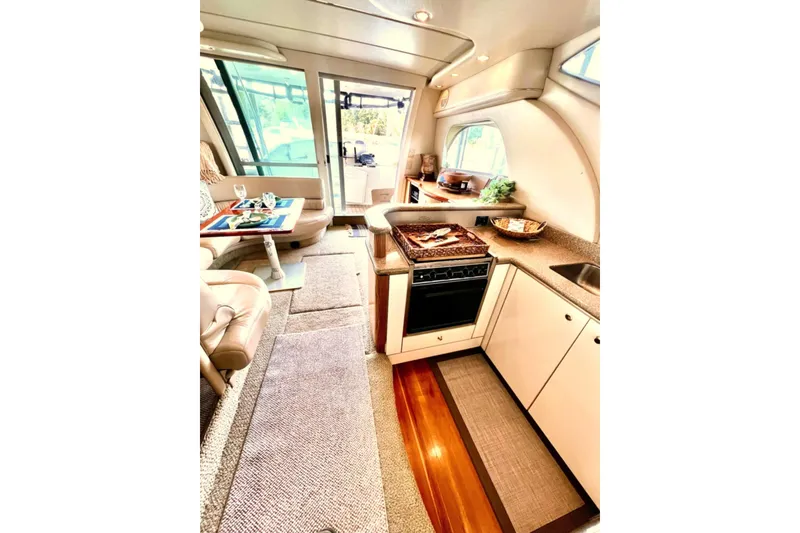 Slide: The Image of Interior of 1999 Maxum 4100 SCB yacht featuring kitchen and dining area. - 12