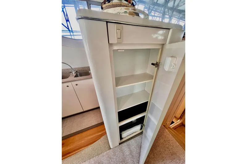 Slide: The Image of Open cabinet with shelves inside a 1999 Maxum 4100 SCB yacht interior. - 14