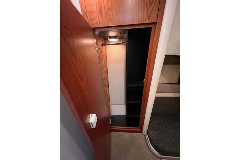 Slide: The Image of 1999 Maxum 4100 SCB yacht interior closet with wooden door and shelves. - 25
