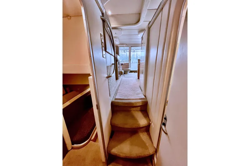 Slide: The Image of Interior view of 1999 Maxum 4100 SCB yacht, featuring carpeted stairs and cozy cabin space. - 26
