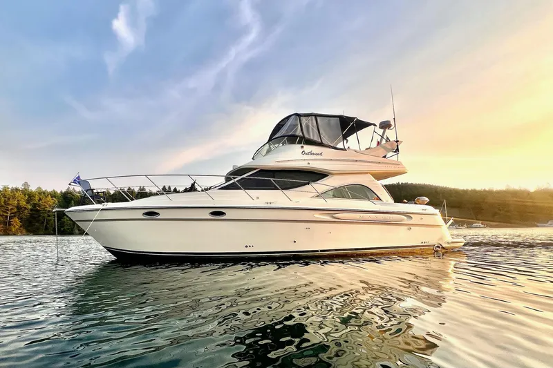 Slide: The Image of 1999 Maxum 4100 SCB yacht on serene water at sunset. - 3