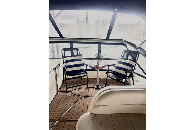Slide: The Image of 1999 Maxum 4100 SCB yacht interior with striped chairs and table on deck. - 38