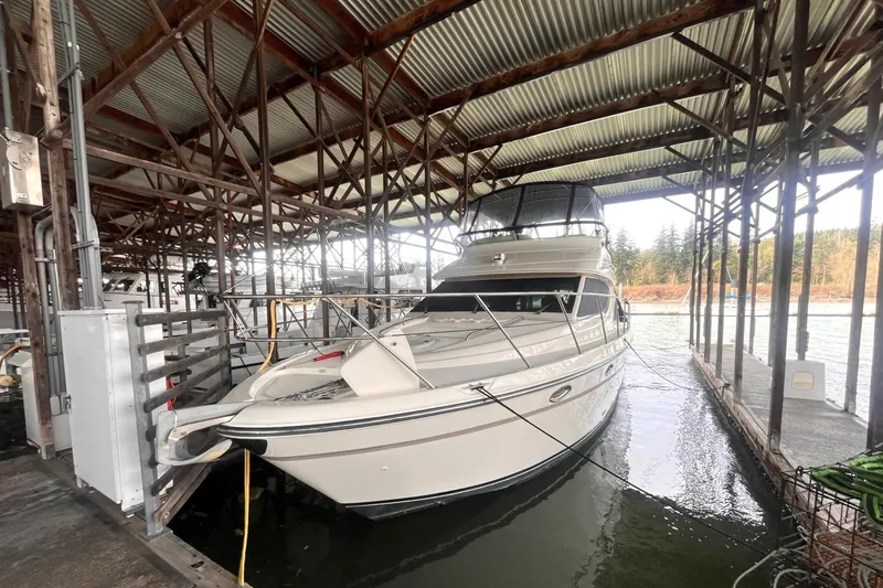 Slide: The Image of 1999 Maxum 4100 SCB yacht docked in a covered marina slip. - 43