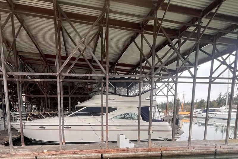 Slide: The Image of 1999 Maxum 4100 SCB yacht docked in a covered marina. - 44