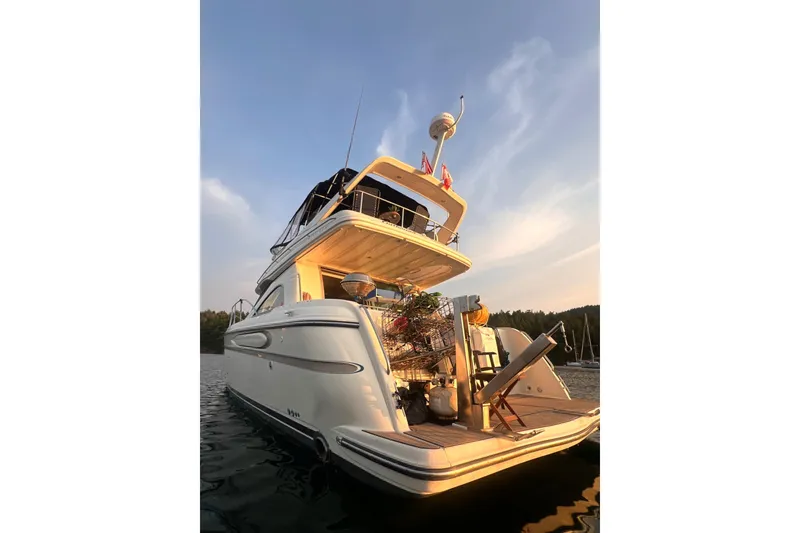 Slide: The Image of 1999 Maxum 4100 SCB yacht at sunset, docked on calm water. - 46