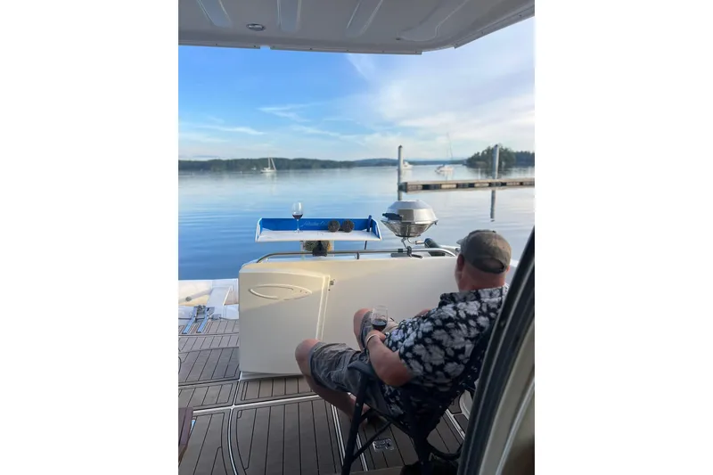 Slide: The Image of Man relaxing on a 1999 Maxum 4100 SCB yacht, enjoying a scenic waterfront view. - 48