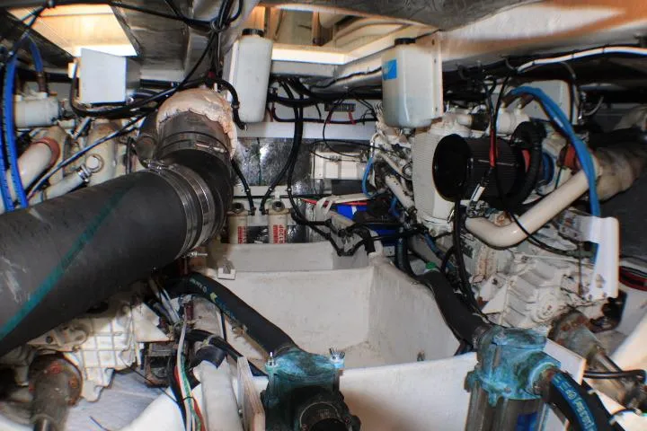Slide: The Image of Engine room of a 1999 Maxum 4100 SCB boat, showcasing mechanical components and wiring. - 49