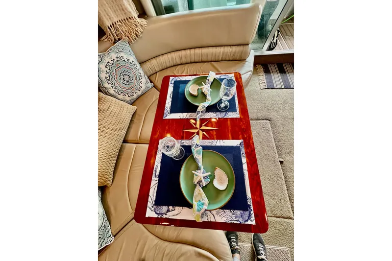 Slide: The Image of Elegant dining setup on 1999 Maxum 4100 SCB yacht with nautical-themed decor. - 7