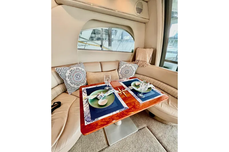 Slide: The Image of Luxurious dining area inside 1999 Maxum 4100 SCB yacht with elegant table setting. - 8