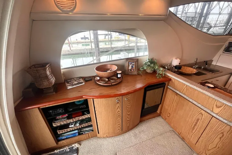 Slide: The Image of Interior of 1999 Maxum 4100 SCB yacht with wooden cabinetry and decorative items. - 9