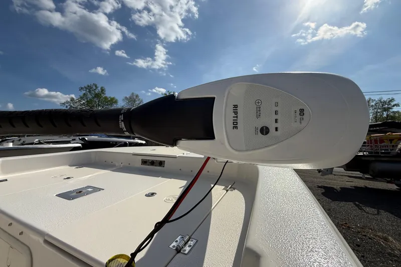 Slide: The Image of 2023 Carolina Skiff 19 LS boat with Riptide trolling motor under a clear sky. - 12