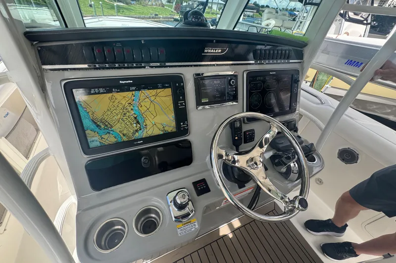Slide: The Image of Boston Whaler 350 Outrage 2014 helm with navigation screens and steering wheel. - 11