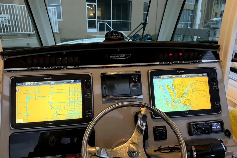 Slide: The Image of Control panel of a 2014 Boston Whaler 350 Outrage with navigation screens and steering wheel. - 14