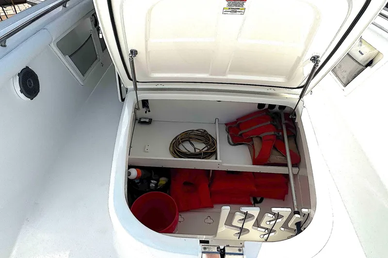 Slide: The Image of Open storage compartment on 2014 Boston Whaler 350 Outrage with life jackets and equipment. - 16