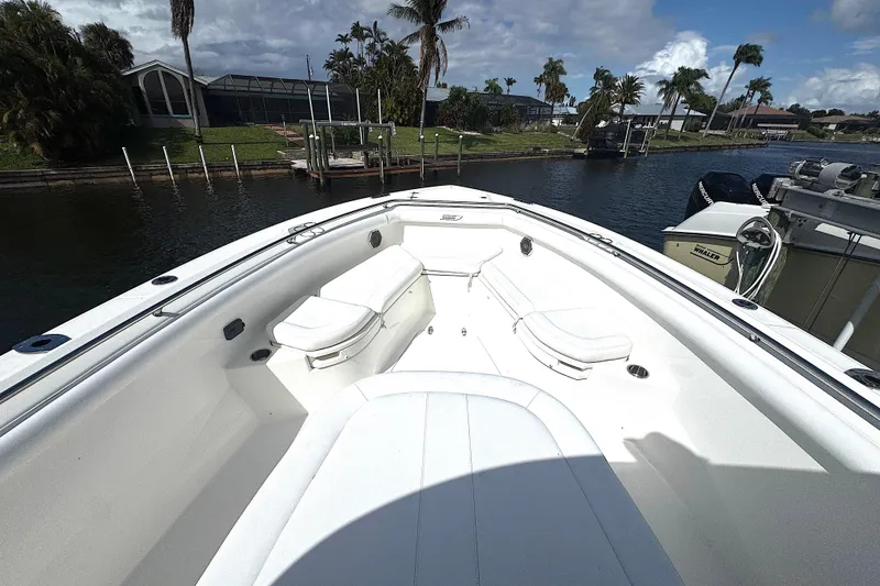 Slide: The Image of 2014 Boston Whaler 350 Outrage boat interior with seating, docked by a canal. - 19