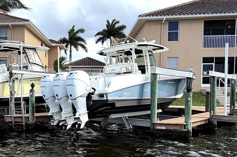 Slide: The Image of 2014 Boston Whaler 350 Outrage boat docked near waterfront home. - 2
