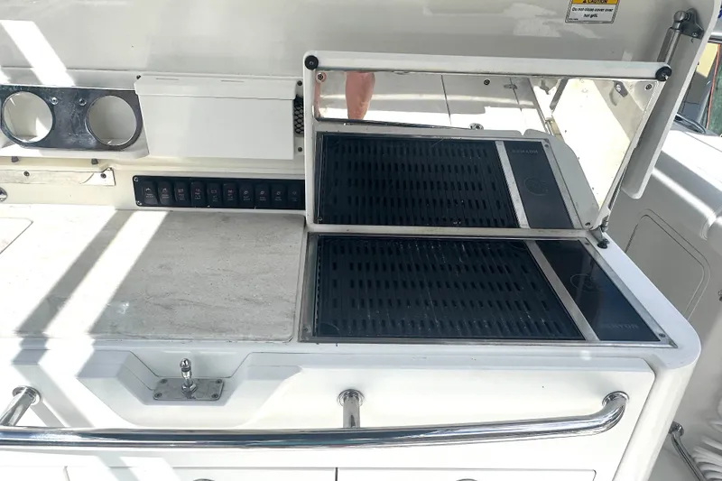 Slide: The Image of 2014 Boston Whaler 350 Outrage boat grill and prep station with storage and controls. - 24