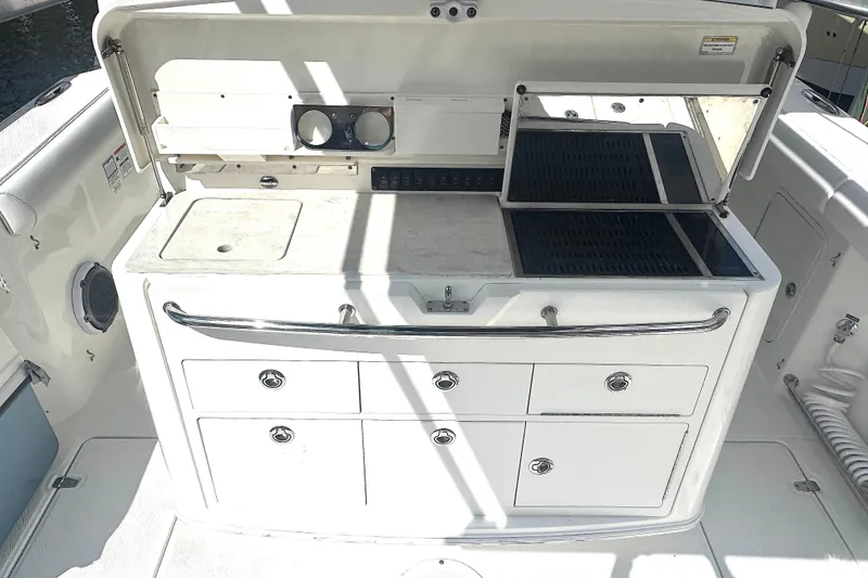 Slide: The Image of 2014 Boston Whaler 350 Outrage boat kitchen area with storage and grill. - 25