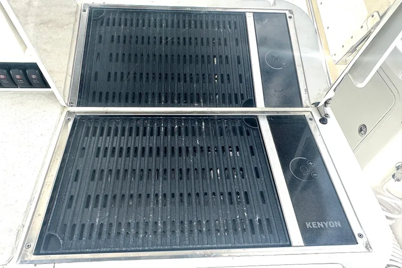 Slide: The Image of Kenyon grill on 2014 Boston Whaler 350 Outrage boat, featuring dual cooking surfaces. - 29