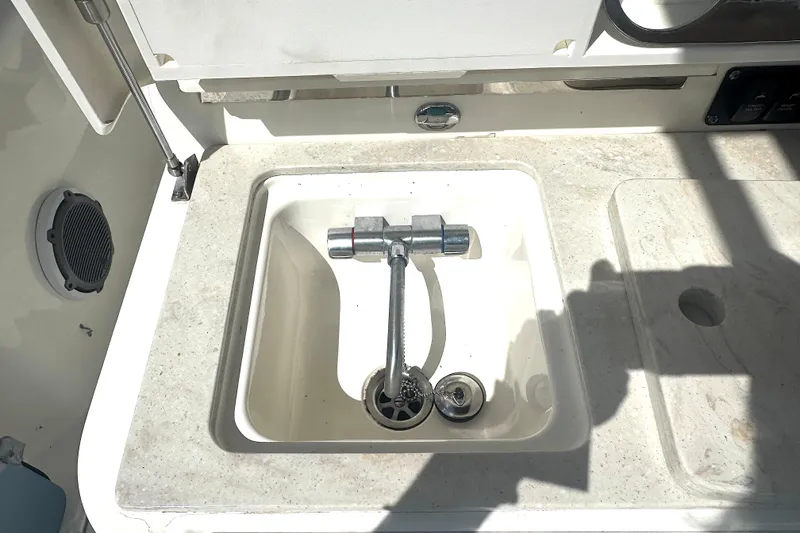 Slide: The Image of Boston Whaler 350 Outrage 2014 boat sink with chrome faucet and countertop. - 30