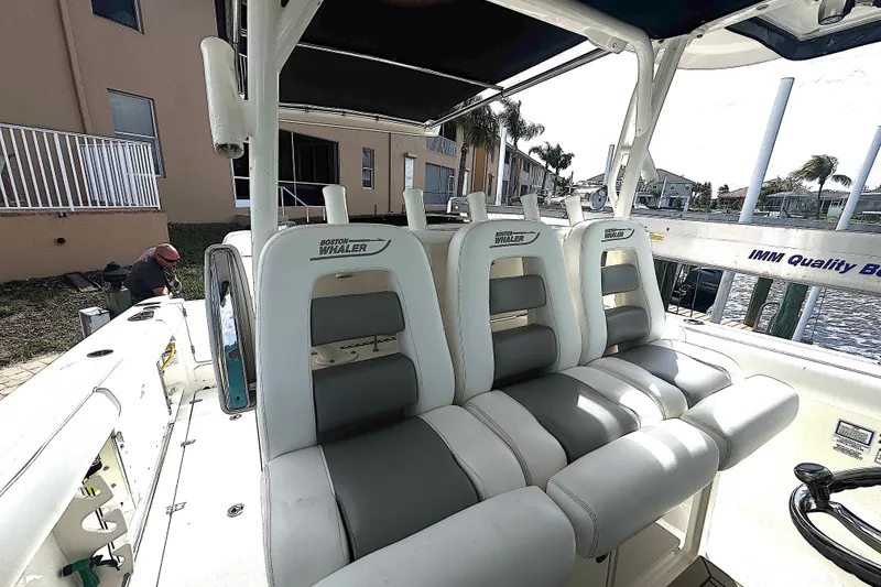 Slide: The Image of 2014 Boston Whaler 350 Outrage boat interior with cushioned seating and waterfront view. - 34