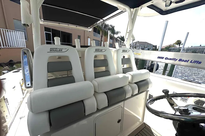 Slide: The Image of 2014 Boston Whaler 350 Outrage boat interior with cushioned seating and steering wheel. - 35