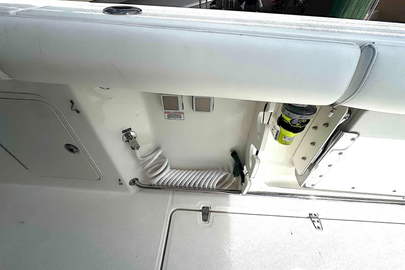 Slide: The Image of 2014 Boston Whaler 350 Outrage deck with coiled hose and storage compartments. - 38