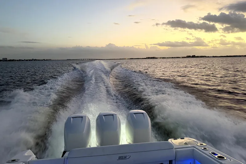 Slide: The Image of 2014 Boston Whaler 350 Outrage cruising at sunset, leaving a wake on the water. - 4