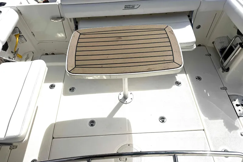 Slide: The Image of 2014 Boston Whaler 350 Outrage deck with wooden table and back and side seating area. - 42