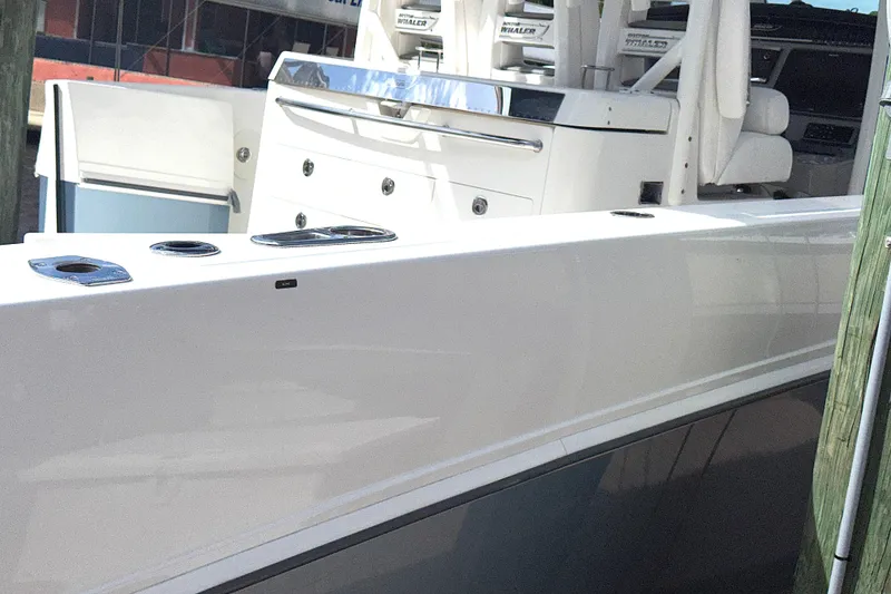 Slide: The Image of 2014 Boston Whaler 350 Outrage boat docked, showcasing sleek white exterior. - 46