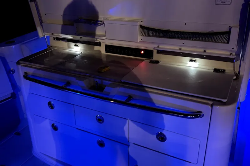 Slide: The Image of 2014 Boston Whaler 350 Outrage interior with illuminated storage and work area. - 65