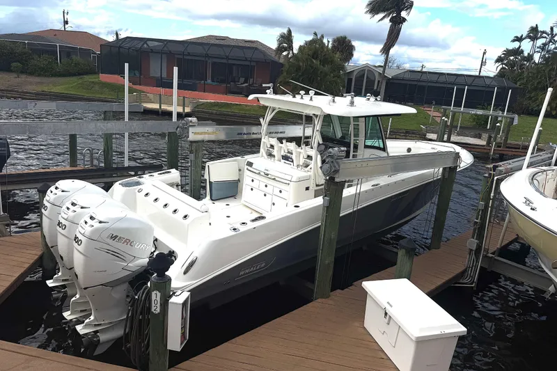 Slide: The Image of 2014 Boston Whaler 350 Outrage docked, featuring triple Mercury engines. - 7