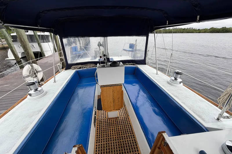 Slide: The Image of Cockpit of 2011 Custom Build 50' Ketch, featuring blue seating and wooden flooring. - 21