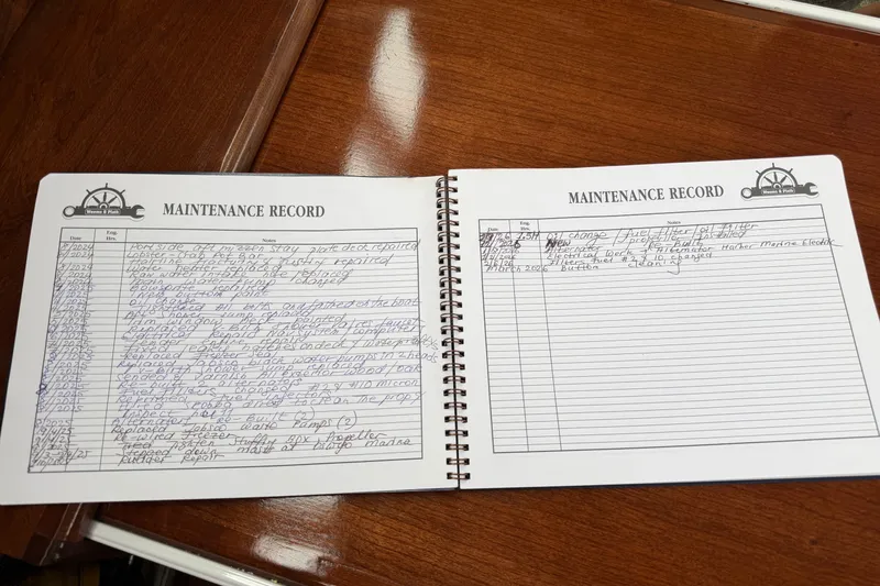 Slide: The Image of Open maintenance record book for a 2011 Custom Build 50' Ketch, detailing repairs and updates. - 39