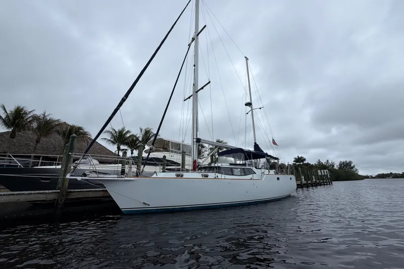 Slide: The Image of Custom Build 50' Ketch, 2011, docked under cloudy skies, palm trees in background. - 2