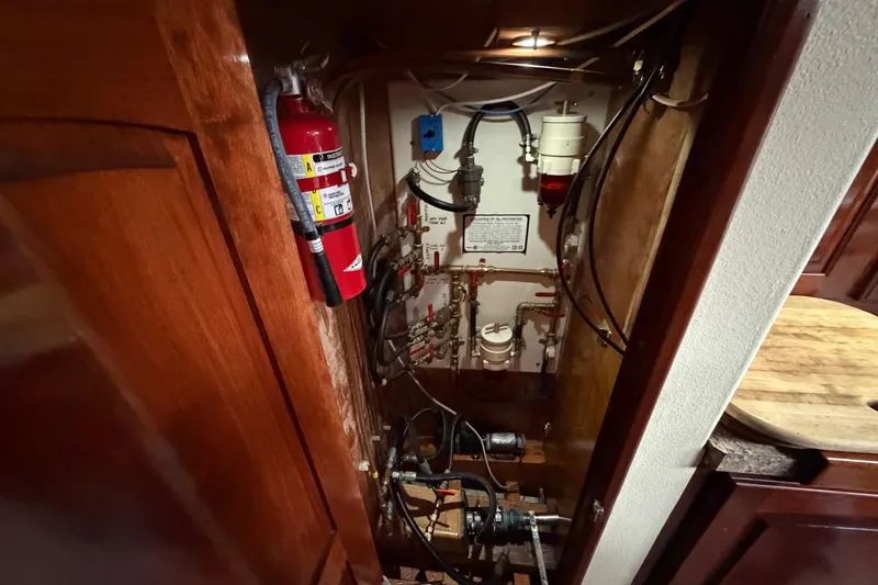 Slide: The Image of Engine room of 2011 Custom Build 50' Ketch, featuring fire extinguisher and mechanical components. - 58