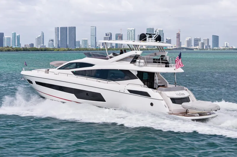 The Image of 2018 Sunseeker 75 Sport Yacht cruising near city skyline, displaying luxury and speed. - 0