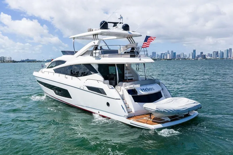 Slide: The Image of 2018 Sunseeker 75 Sport Yacht cruising near city skyline, featuring sleek design and luxury amenities. - 16
