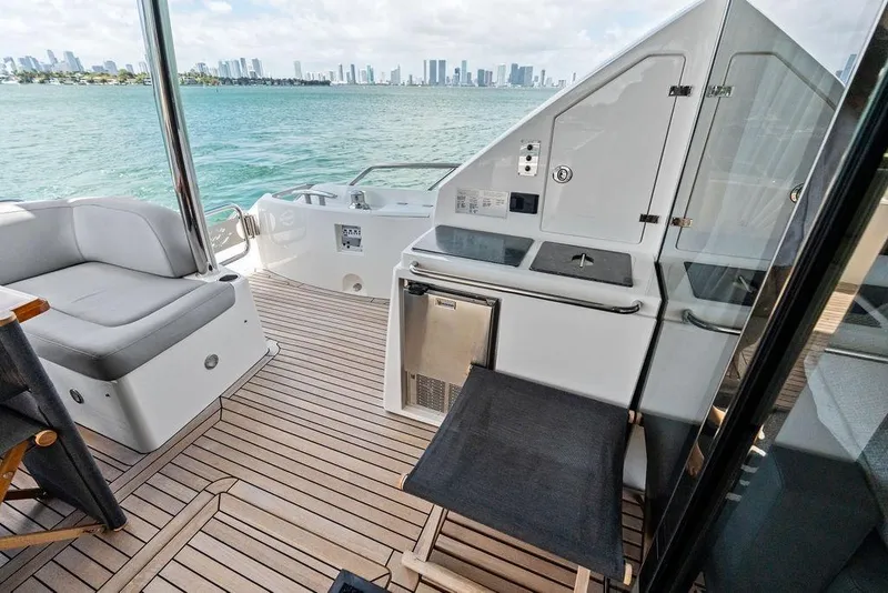 Slide: The Image of Sunseeker 75 Sport Yacht 2018 deck with seating, kitchenette, and ocean view. - 20