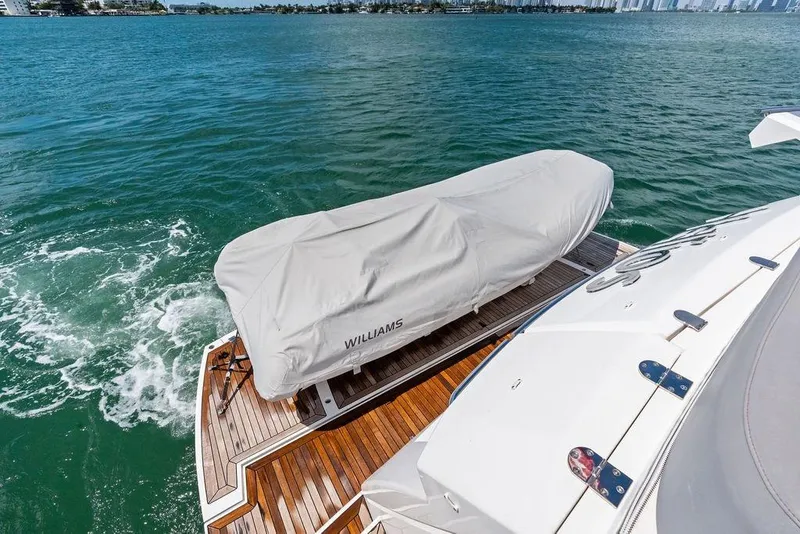 Slide: The Image of Sunseeker 75 Sport Yacht 2018 with covered tender on teak deck, cruising in open water. - 22