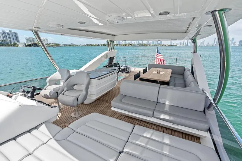 Slide: The Image of Luxurious 2018 Sunseeker 75 Sport Yacht deck with seating, ocean view, and city skyline. - 32