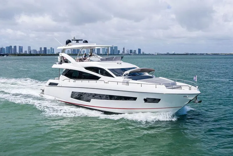 Slide: The Image of Luxurious 2018 Sunseeker 75 Sport Yacht cruising on open water with city skyline backdrop. - 8
