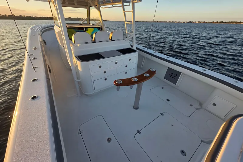 Slide: The Image of 2019 Yellowfin 42 Offshore boat interior, featuring spacious deck and seating, on calm waters. - 12