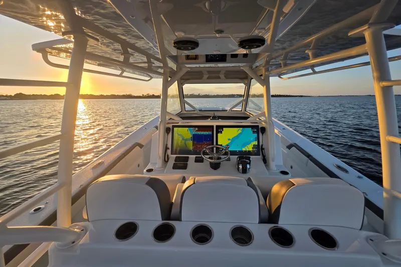 Slide: The Image of 2019 Yellowfin 42 Offshore boat interior with navigation screens at sunset on the water. - 16